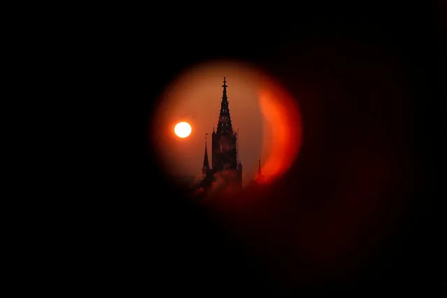 The sun rises behind the Muenster Cathedral during a cold morning in Bern, Switzerland February 28, 2018. Picture taken through a metal pipe. (Photo by Stefan Wermuth/Reuters)