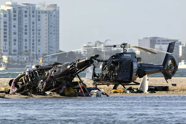 Two cashed helicopters sit on the sand at a collision scene near Seaworld, on the Gold Coast, Australia, Monday, January 2, 2023. The 2 helicopters collided killing several passengers and critically injuring a few others in a crash that drew emergency aid from beachgoers enjoying the water during the southern summer. (Photo by Dave Hunt/AAP Image via AP Photo)