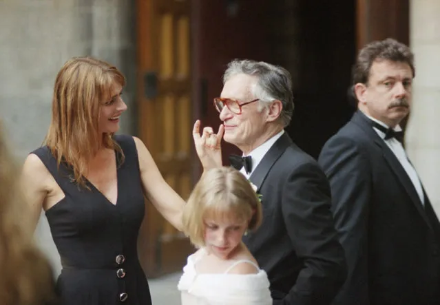 In this Saturday, July 15, 1995 file photo, Playboy Enterprises founder Hugh Hefner, center, gets a touch up to his appearance by his wife, Kimberley Conrad, left, following his daughter Christie Hefner's wedding at the University of Chicago's Rockefeller Chapel. Christie Hefner, the CEO of Playboy Enterprises, married former Illinois State Senator Bill Marovitz. (Photo by John Zich/AP Photo)