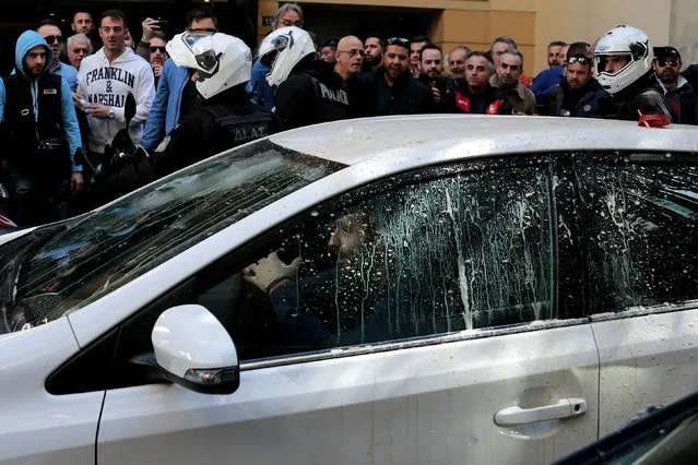Greek taxi drivers surround a vehicle they say is being used by an Uber driver during a protest against taxi-hailing apps such as Uber in Athens, Greece March 6, 2018. (Photo by Alkis Konstantinidis/Reuters)