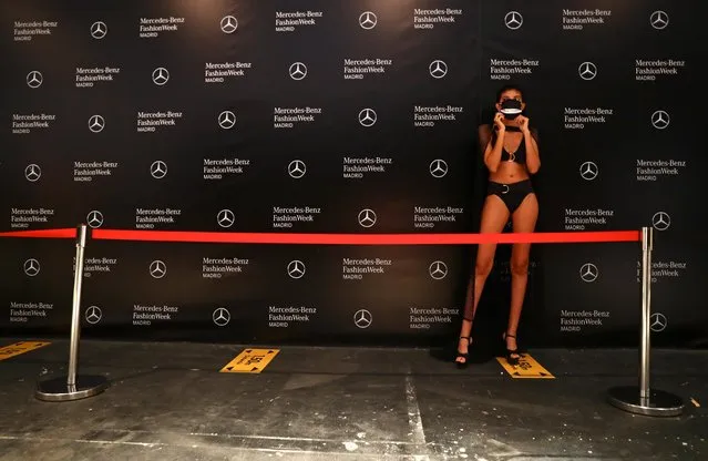 Social distancing signs are pictured as a model wears a protective face mask before the show of designer Andres Sarda during the Mercedes Benz Fashion Week amid the coronavirus disease (COVID-19) outbreak in Madrid, Spain, September 10, 2020. (Photo by Sergio Perez/Reuters)