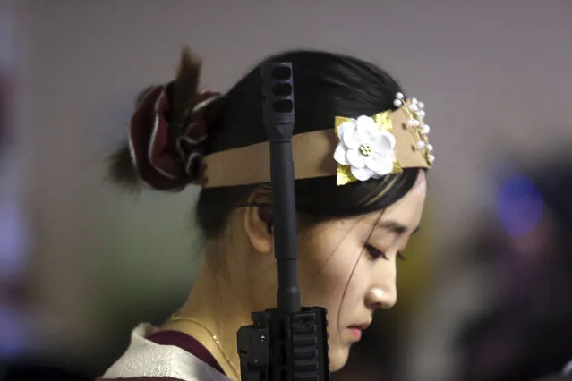 A standing woman holds an unloaded weapon during services at the World Peace and Unification Sanctuary, Wednesday February 28, 2018 in Newfoundland, Pa. Worshippers clutching AR-15 rifles participated in a commitment ceremony at the Pennsylvania-based church.The event Wednesday morning led a nearby school to cancel classes for the day. The church's leader, the Rev. Sean Moon, said in a prayer that God gave people the right to bear arms. (Photo by Jacqueline Larma/AP Photo)