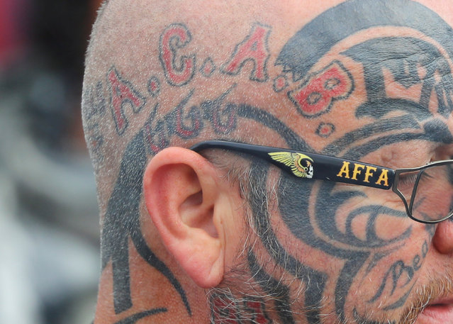 A member of the Hells Angels with a tattoo that reads A.C.A.B (“All Cops Are Bastards”) wears glasses that read “AFFA” (“Angels For ever – For ever Angels”) during the funeral of Aygun Mucuk, president of the Giessen chapter of the Hells Angels in Giessen, Germany, October 12, 2016. (Photo by Kai Pfaffenbach/Reuters)