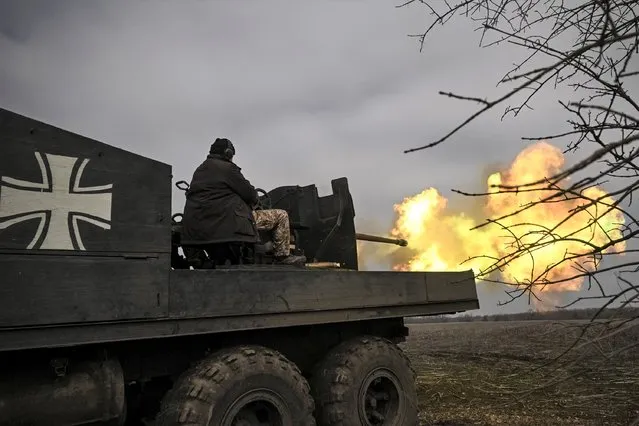 Ukrainian servicemen fire with an S60 anti-aircraft gun at Russian positions near Bachmut on March 20, 2023, amid the Russian invasion of Ukraine. (Photo by Aris Messinis/AFP Photo)