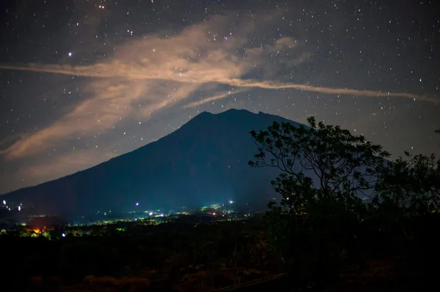 This long exposure photograph shows Mount Agung under a starry sky as seen from Kubu in Karangasem on the Indonesian resort island of Bali on September 28, 2017. Indonesian authorities are on standby to divert flights destined for the holiday island of Bali as increasingly frequent tremors from a rumbling volcano stoke fears an eruption could be imminent. (Photo by Bay Ismoyo/AFP Photo)