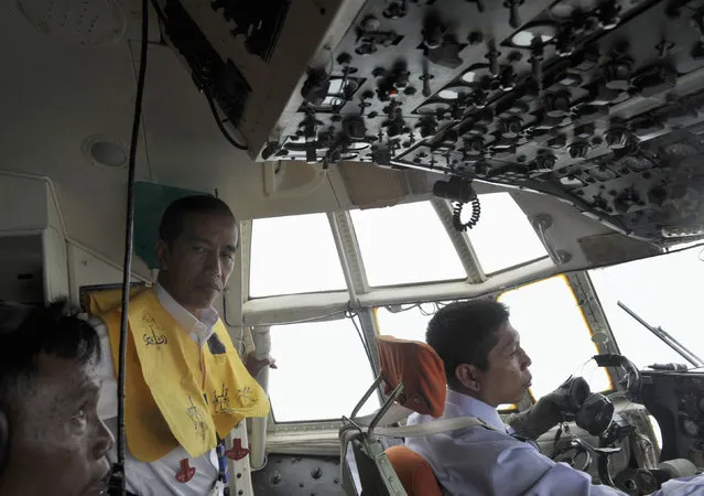 Indonesian President Joko Widodo (C) oversees the aerial search operation for missing AirAsia Flight QZ8501, on board a Hercules over the sea south of  Pangkalan Bun, central Kalimantan December 30, 2014 in this photo taken by Antara Foto. (Photo by Andika Wahyu/Reuters/Antara Foto)