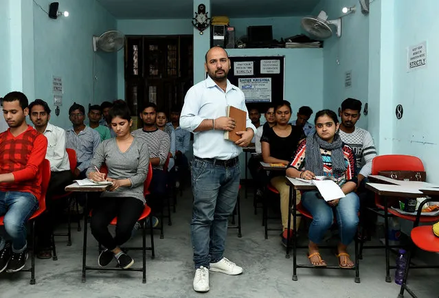 Surbir Singh, 35, an Indian shorthand teacher, poses for a picture at a stenography centre surrounded by students in Faridabad on April 24, 2018. (Photo by Money Sharma/AFP Photo)