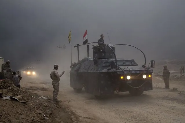 An Iraqi Federal Police vehicle passes through a checkpoint in Qayara, some 50 kilometers south of Mosul, Iraq, Wednesday, October 26, 2016. Islamic State militants have been going door to door in farming communities south of Mosul, ordering people at gunpoint to follow them north into the city and apparently using them as human shields as they retreat from Iraqi forces. Witnesses to the forced evacuation describe scenes of chaos as hundreds of people were driven north across the Ninevah plains and into the heavily-fortified city, where the extremists are believed to be preparing for a climactic showdown. (Photo by Marko Drobnjakovic/AP Photo)