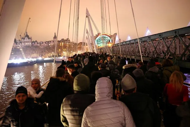 People walk along Hungerford Bridge during a demonstration and a New Year's celebration, amid the outbreak of the coronavirus disease (COVID-19), in London, Britain on January 1, 2021. (Photo by Henry Nicholls/Reuters)