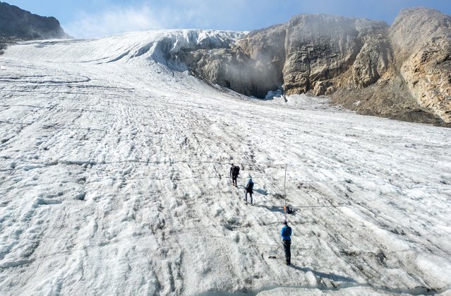 A drone view shows glaciologist Matthias Huss of ETH Zurich and his colleagues Lander van Tricht and Andreas Linsbauer walking on the Gries glacier during a field trip, amid the impact of climate change, in Obergoms, Switzerland, on September 11, 2025. (Photo by Denis Balibouse/Reuters)