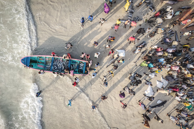 A general view of an open-air beachside market where local fishermen land their catch at dawn in Mogadishu, on November 12, 2025. Mogadishu is rising, literally, from the ashes of decades of war. Pavements remain scarred by bullet holes and ruined buildings still line many streets, but the city's cacophony is now one of construction, not destruction. The east African nation saw civil war in the 1990s mutate into an Islamist insurgency in the 2000s that still threatens much of the country. (Photo by Eden Ezra/AFP Photo via Getty Images)