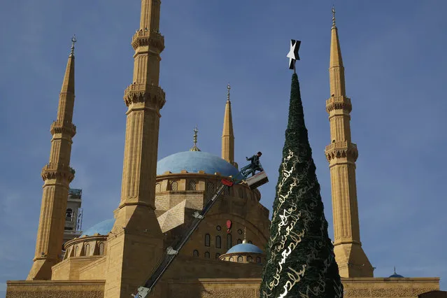 A worker decorates a Christmas tree designed by Lebanese designer Elie Saab in front of the Al-Amin mosque in Beirut, Lebanon, December 9, 2015. Picture taken December 9, 2015. (Photo by Jamal Saidi/Reuters)