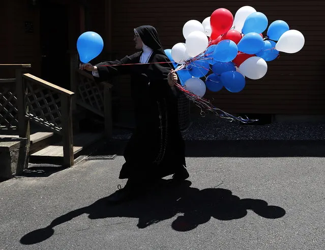 Traditional Catholic nun Sister Marie Collette hands out red white and blue balloons during a Fourth of July parade and celebration at the Motherhouse of the Daughters of Mary Convent in Round Top, New York, USA, 04 July 2018. The Fourth of July is the annual US celebration of the adoption of the Declaration of Independence from Britain. (Photo by Matt Campbell/EPA/EFE)