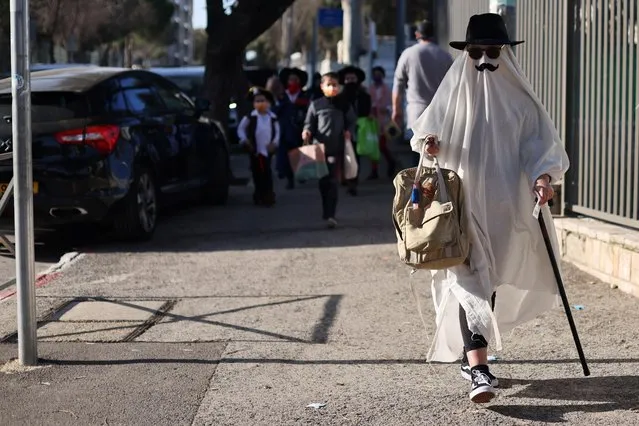 A girl wearing a dress-up costume to mark the upcoming Jewish holiday of Purim, which is a celebration of the Jews' salvation from genocide in ancient Persia, walks to her school in Jerusalem on February 24, 2021. (Photo by Ammar Awad/Reuters)