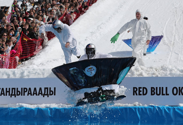 A participant wearing a fancy costume jumps into a pond of icy water during the Red Bull Jump and Freeze competition at Shymbulak ski resort outside Almaty, Kazakhstan, on March 22, 2025. (Photo by Pavel Mikheyev/Reuters)