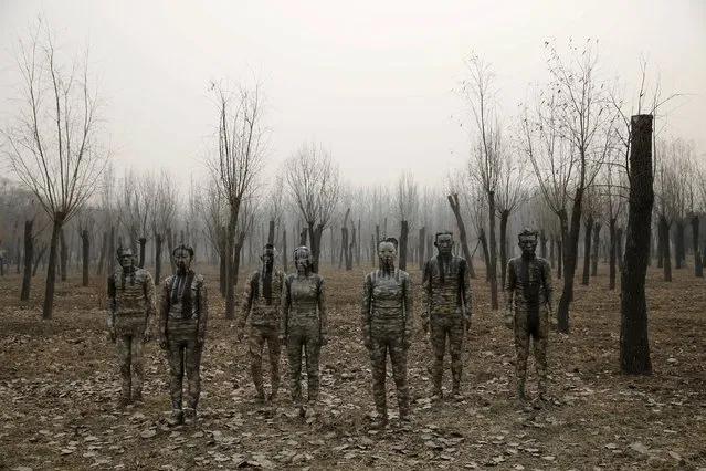 Models painted in camouflage colours to blend in with the background pose for Chinese artist Liu Bolin's artwork “Dongji”, or Winter Solstice, on the second day after China's capital Beijing issued its second ever “red alert” for air pollution, in Beijing, China, December 20, 2015. (Photo by Kim Kyung-Hoon/Reuters)