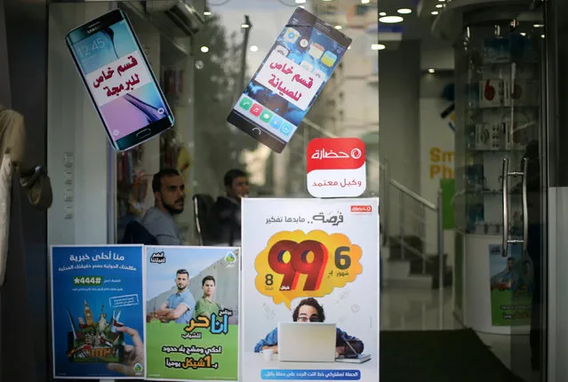 Palestinian sellers sit in a mobile phone and internet services shop in Gaza City November 16, 2016. (Photo by Ibraheem Abu Mustafa/Reuters)