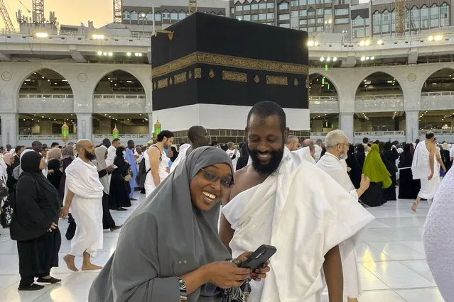 Somalian pilgrims prepare for a selfie in front of the Kaaba, the cubic building at the Grand Mosque, during the annual hajj pilgrimage in Mecca, Saudi Arabia, Monday, June 26, 2023, before heading to Mina in preparation for the Hajj, the fifth pillar of Islam and one of the largest religious gatherings in the world. (Photo by Amr Nabil/AP Photo)