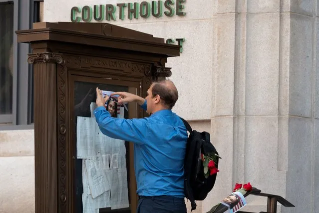A supporter places roses and a photo of Fulton County District Attorney Fani Willis near the entrance of the Lewis R. Slaton Courthouse after a Grand Jury brought back indictments against former president Donald Trump and 18 of his allies in their attempt to overturn the state's 2020 election results, in Atlanta, Georgia, U.S. August 15, 2023. (Photo by Cheney Orr/Reuters)