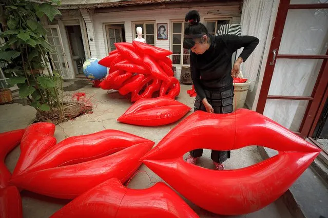 Artist and environmental activist Kong Ning prepares inflatable lip-shaped balloons for her latest gown collection with a theme “Kiss the earth” in support on Earth Day in Beijing, Thursday, April 22, 2021. (Photo by Andy Wong/AP Photo)
