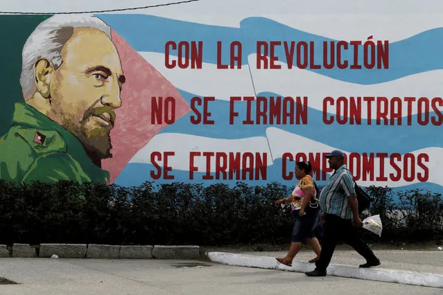 People walks pass a graffiti of Cuba's late president Fidel Castro in Santiago de Cuba, Cuba December 3, 2016. (Photo by Enrique de la Osa/Reuters)