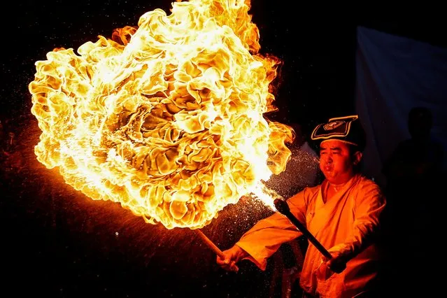 A Tao priest blows a fire as a part of a ritual during the Hungry Ghost Festival in Damansara, Malaysia, 26 August 2023. According to a Chinese tradition, the seventh month in the Chinese lunar calendar is called the Ghost Month in which ghosts and spirits are believed to come out from hell to visit the Earth. (Photo by Fazry Ismail/EPA/EFE)