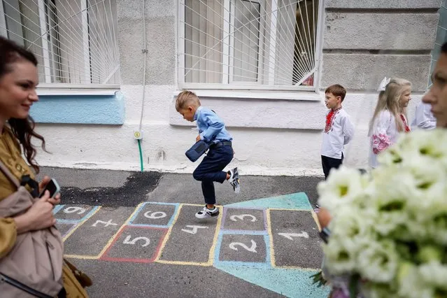 First graders play near a school before a ceremony to mark the start of the new school year, amid Russia's attack on Ukraine, in Kyiv, Ukraine on September 1, 2023. (Photo by Gleb Garanich/Reuters)