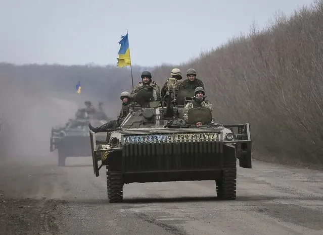 Members of the Ukrainian armed forces ride armoured personnel carriers near Debaltseve, eastern Ukraine, February 20, 2015. Fighting persisted in east Ukraine on Friday despite new European efforts to ensure a ceasefire takes hold.  REUTERS/Gleb Garanich  (UKRAINE - Tags: POLITICS CIVIL UNREST MILITARY CONFLICT)