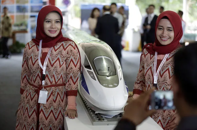 Indonesian Muslim women pose for a photo near the model of the high-speed train which will connect the capital city of Jakarta to the country's fourth largest city, Bandung, during the groundbreaking ceremony for the construction of its railway in Cikalong Wetan, West  Java, Indonesia, Thursday, January 21, 2016. (Photo by Dita Alangkara/AP Photo)