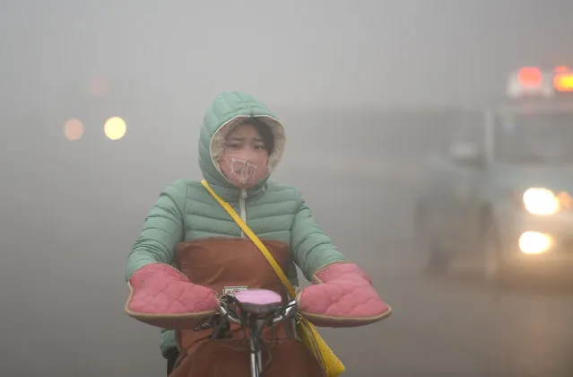 A citizen rides in smog on December 20, 2016 in Jinan, Shandong Province of China. Air quality index (AQI) readings exceeded 400 and some schools have suspended classes in Jinan. (Photo by VCG/VCG via Getty Images)