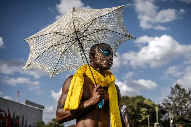 A model holds an umbrella while walking the catwalk at the main fashion show during the Kibera Fashion Week in the informal settlement of Kibera in Nairobi, on October 15, 2023. (Photo by Luis Tato/AFP Photo)