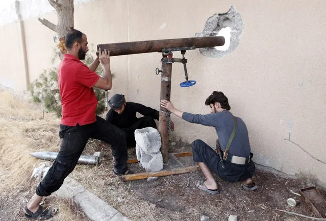 Free Syrian Army fighters prepare to fire rockets towards forces loyal to Syria's president Bashar al-Assad  in Raqqa, eastern Syria October 14, 2013. (Photo by Nour Fourat/Reuters)
