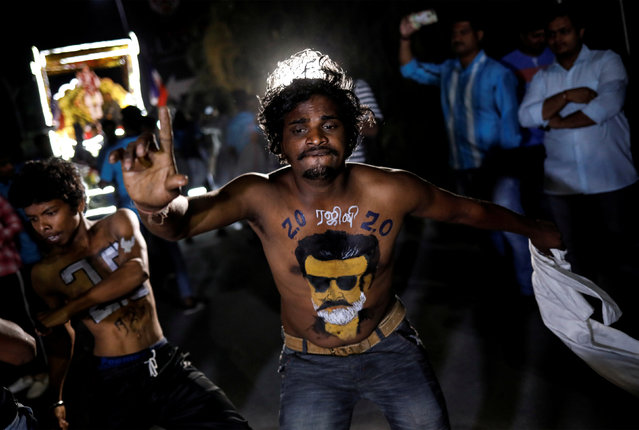 A fan with his body painted with image of Tamil film star Rajinikanth dances as he celebrates the release of his new movie “2.0” in Mumbai, India, November 29, 2018. (Photo by Danish Siddiqui/Reuters)