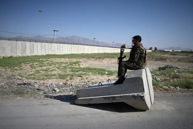 An Afghan National Army (ANA) soldier sits at a road checkpoint near the a US military base in Bagram, some 50 km north of Kabul on July 1, 2021. (Photo by Wakil Kohsar/AFP Photo)