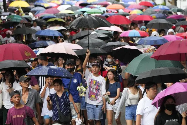 People use umbrellas during a drizzle as they flock inside Manila's North Cemetery, Philippines on Wednesday, November 1, 2023. Many Filipinos trooped to cemeteries to visit the graves of their departed loved ones as part of tradition during All Saints' Day. (Photo by Aaron Favila/(AP Photo)