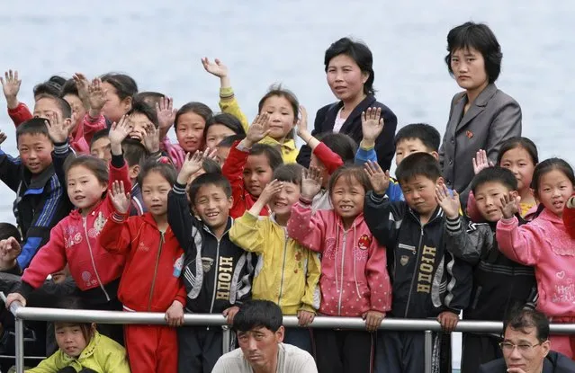 North Korean children wave during their trip on the Yalu River in Sinuiju, opposite the Chinese border city of Dandong, May 15, 2013. (Photo by Jacky Chen/Reuters)
