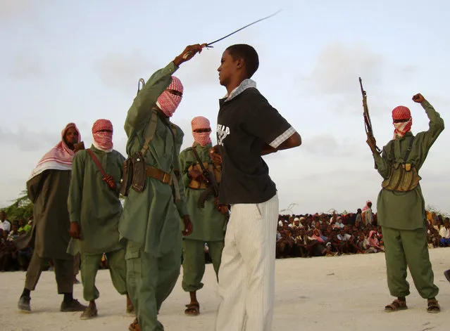 The toppling by warlords of military dictator Mohamed Siad Barre in 1991 plunged the Horn of Africa nation into anarchy, allowing al Shabaab, which means “Youth” or “Boys” in Arabic, to seize control of large areas of south and central Somalia. Here: an Islamist fighter from al Shabaab Mujaahidin lashes one of the four youths who confessed to raping a woman, on the outskirts of Mogadishu, March 9, 2009. (Photo by Feisal Omar/Reuters)