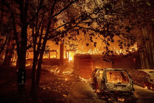 Flames consume a home as the Dixie Fire tears through the Indian Falls community in Plumas County, Calif., Saturday, July 24, 2021. (Photo by Noah Berger/AP Photo)