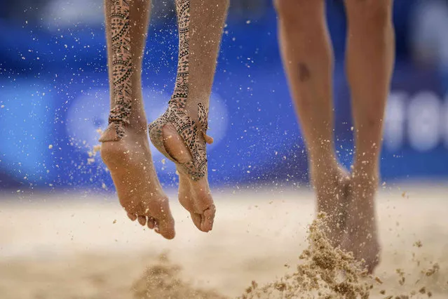 Konstantin Semenov, left, of the Russian Olympic Committee, with tape on his feet jumps during a men's beach volleyball match against Australia at the 2020 Summer Olympics, Monday, July 26, 2021, in Tokyo, Japan. (Photo by Petros Giannakouris/AP Photo)