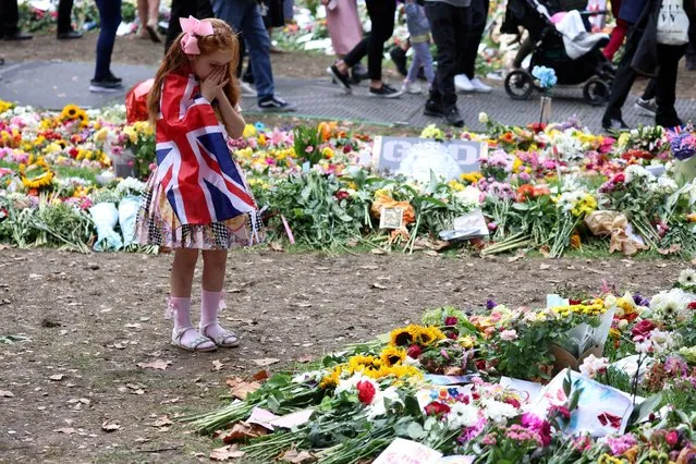 Six year old Ann Doran reats near floral tributes left at Green Park, following the death of Britain's Queen Elizabeth, in London, Britain on September 15, 2022. (Photo by Phil Noble/Reuters)