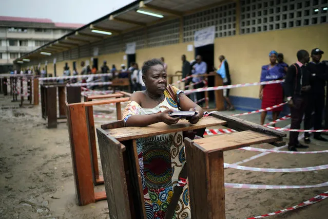 Congolese voters wait at the St. Raphael school in the Limete district of Kinshasa Sunday, December 30, 2018, for voter's listings that have not arrived. People had started to gather at 6am to cast their votes, and four hours later, vote had not started as the lists were not available. Forty million voters are registered for a presidential race plagued by years of delay and persistent rumors of lack of preparation. (Photo by Jerome Delay/AP Photo)
