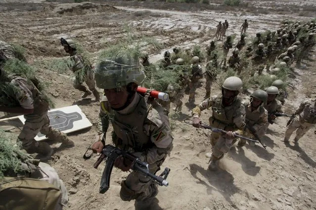 Iraqi security forces walk with thier weapons during military training in Jurf al-Sakhar, Iraq April 9, 2015. (Photo by Alaa Al-Marjani/Reuters)