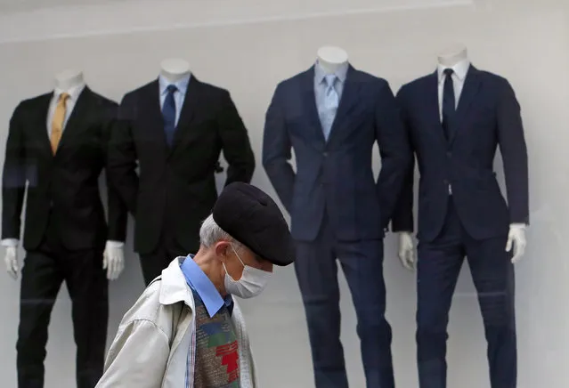 In this Wednesday, March 17, 2021 file photo, a man wearing a mask to protect against coronavirus walks by a closed shop in downtown Belgrade, Serbia. Many regions in Central Europe and the Balkans on Wednesday March 24, 2021, are facing one of the most difficult moments since the coronavirus pandemic struck over a year ago. (Photo by Darko Vojinovic/AP Photo/File)