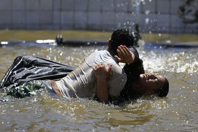 Egyptian boys play in a water fountain as the country marks Sham el-Nessim, or “smelling the breeze”, in Giza, Egypt, Monday, April 13, 2015. (Photo by Hassan Ammar/AP Photo)