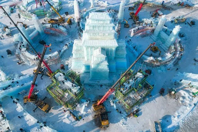 This aerial photo taken on December 14, 2023 shows the construction site of the Harbin Ice and Snow World, a renowned seasonal theme park opening every winter, in Harbin, northeast China's Heilongjiang Province. Harbin Ice and snow World will open for its 25th winter season on Dec. 18. It is estimated that 250,000 cubic meters of ice and snow will be used in its construction. (Photo by Zhang Tao/Xinhua/Alamy Live News)