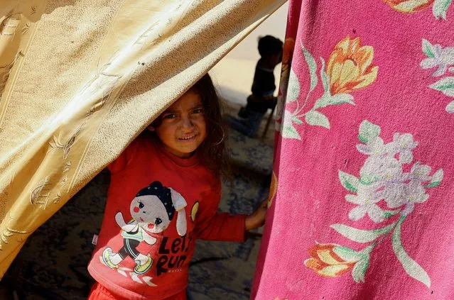 A child looks out of a tent, as displaced Palestinians, who fled their houses due to Israeli strikes, shelter in a tent camp near the border with Egypt, amid the ongoing conflict between Israel and the Palestinian Islamist group Hamas, in Rafah in the southern Gaza Strip on December 11, 2023. (Photo by Mohammed Salem/Reuters)