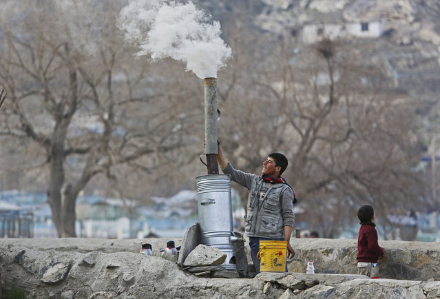An Afghan boy prepares tea as he waits for customers on the outskirts of Kabul, Afghanistan, Friday, March 20, 2015. (Photo by Rahmat Gul/AP Photo)
