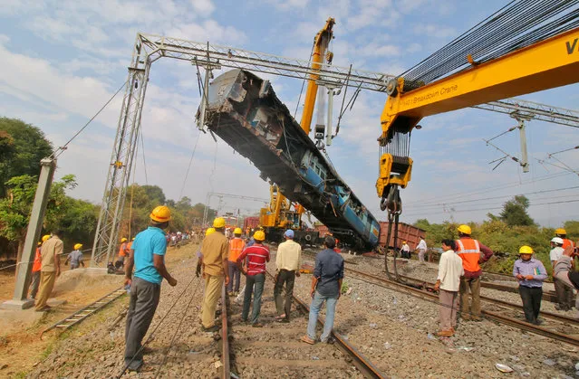 A damaged coach of a passenger train is removed after it derailed near Kuneru village in Vizianagaram district, in the southern state of Andhra Pradesh, India, January 22, 2017. (Photo by Reuters/Stringer)