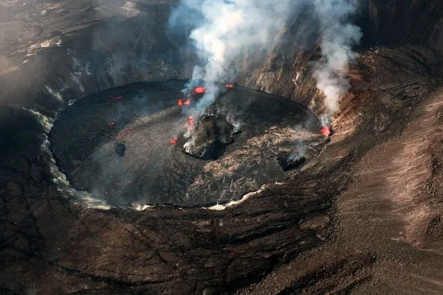 A handout photo made available by the United States Geological Survey (USGS) of an aerial view taken during an overflight showing the eruption in the Halema'uma'u crater at Kilauea volcano's summit, in Hawaii, USA, 30 September 2021. In this image, multiple active fountaining sources are visible in the central and western portions of the Halema'uma'u crater. According to the USGS Hawaiian Volcano Observatory (HVO), a new eruption at Kilauea's summit began on 29 September 2021, with lava activity currently confined within the Halema'uma'u crater. Gas emissions and seismic activity at the summit remain elevated, the HVO added. (Photo by K. Mulliken/USGS/EPA/EFE)