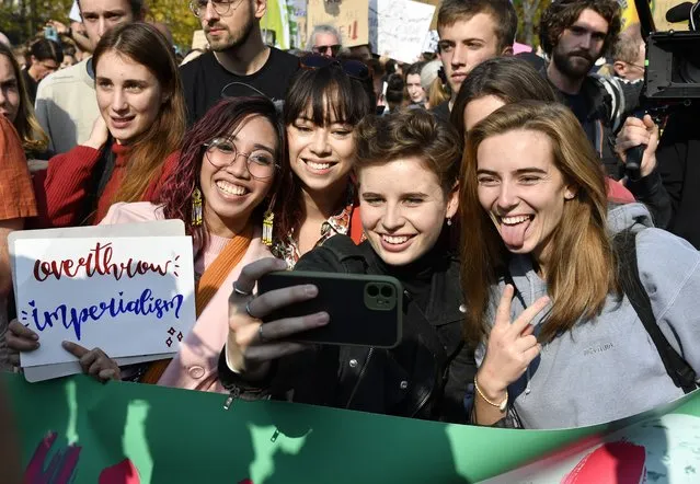 Belgian climate activist Anuna De Wever, center, takes a selfie as she poses with participates in a climate march in Brussels, Sunday, October 10, 2021. (Photo by Geert Vanden Wijngaert/AP Photo)